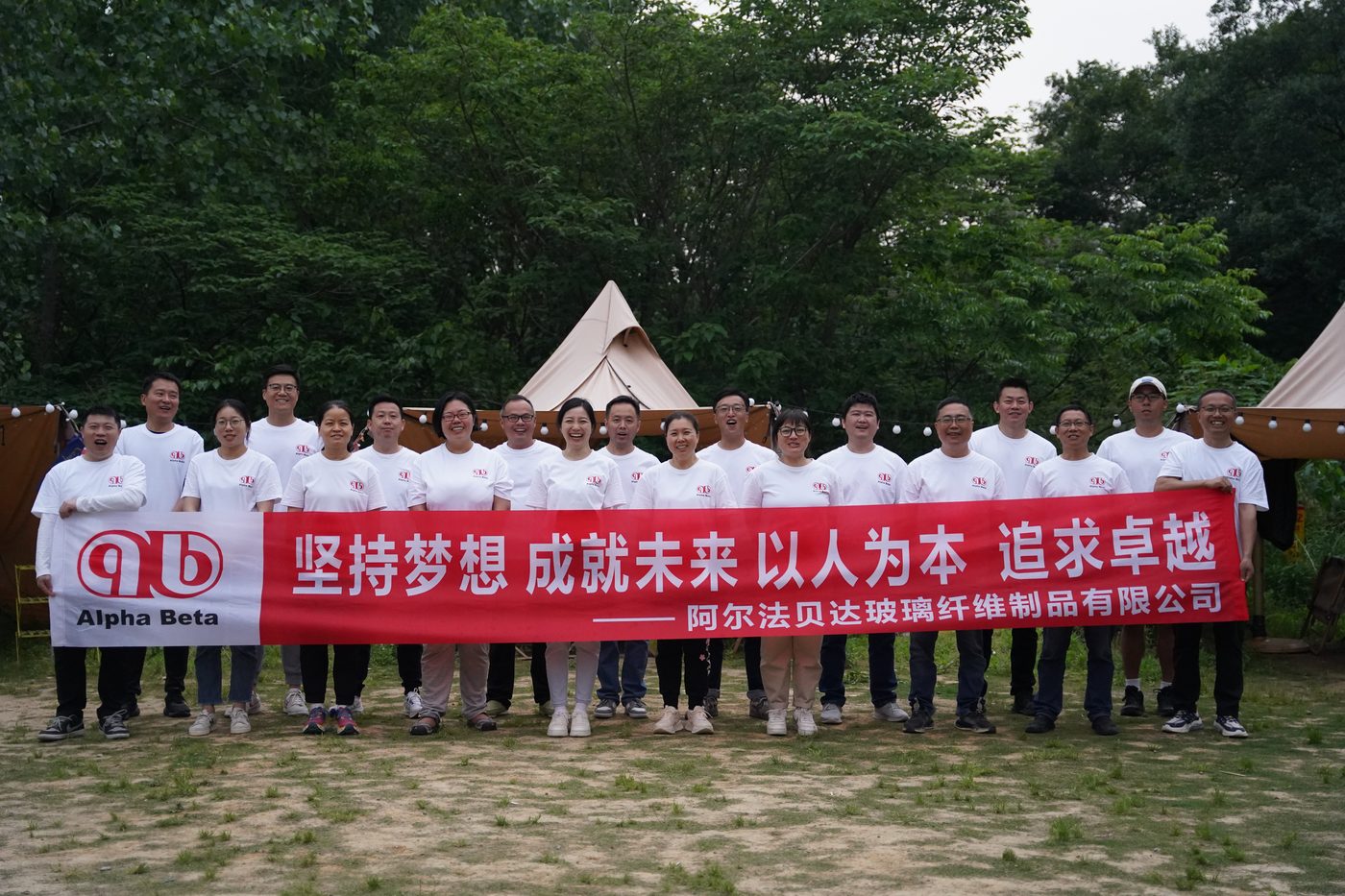 Company team-building group photo with the values banner