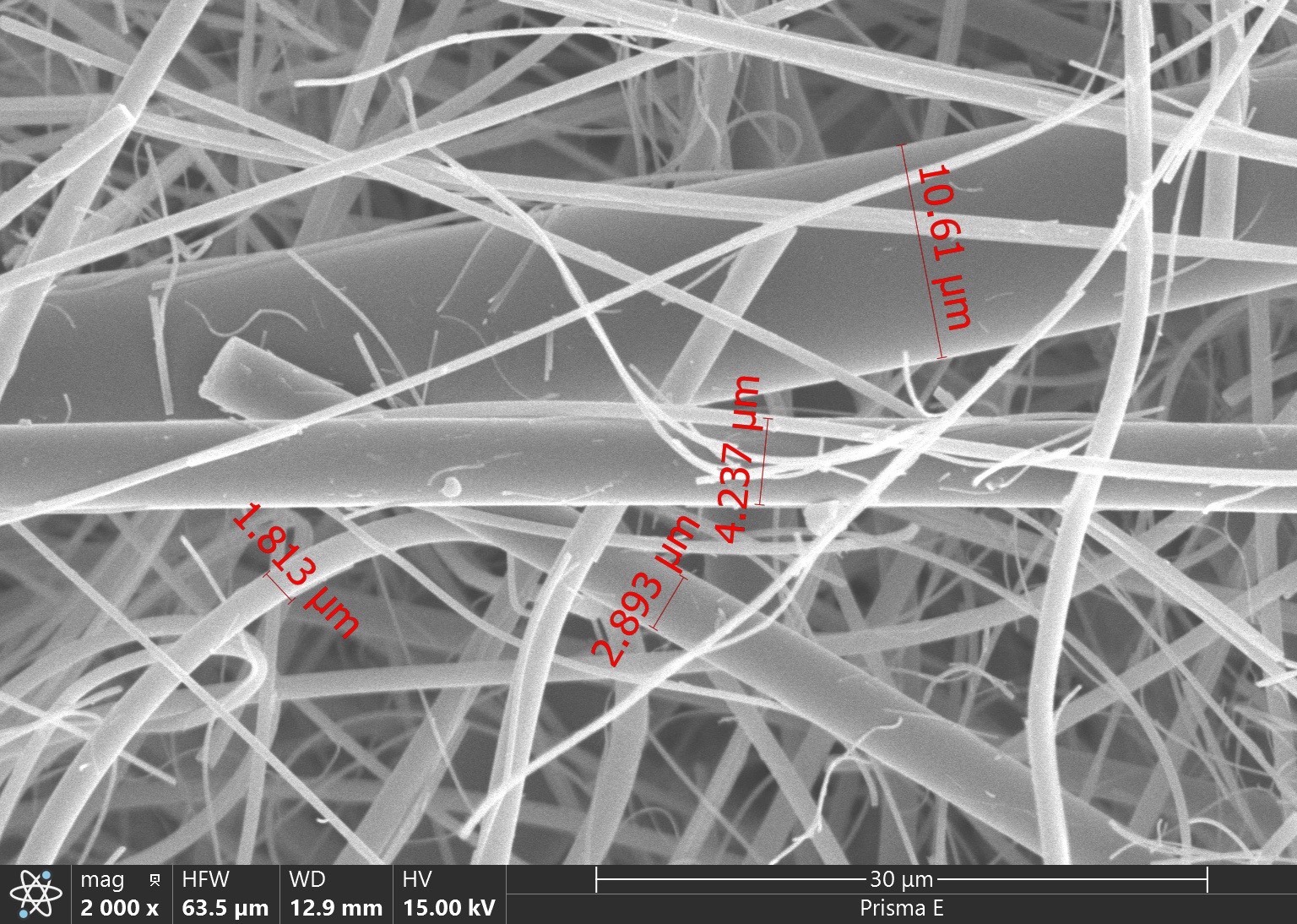 SEM micrograph of a synthetic fiber separator (2026 comparison sample) with fiber diameters annotated between 1.813 and 10.61 micrometres, mixed coarse and fine strands